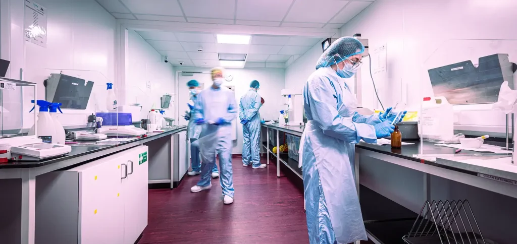 Staff in protective clothing working in a pharmaceutical cleanroom